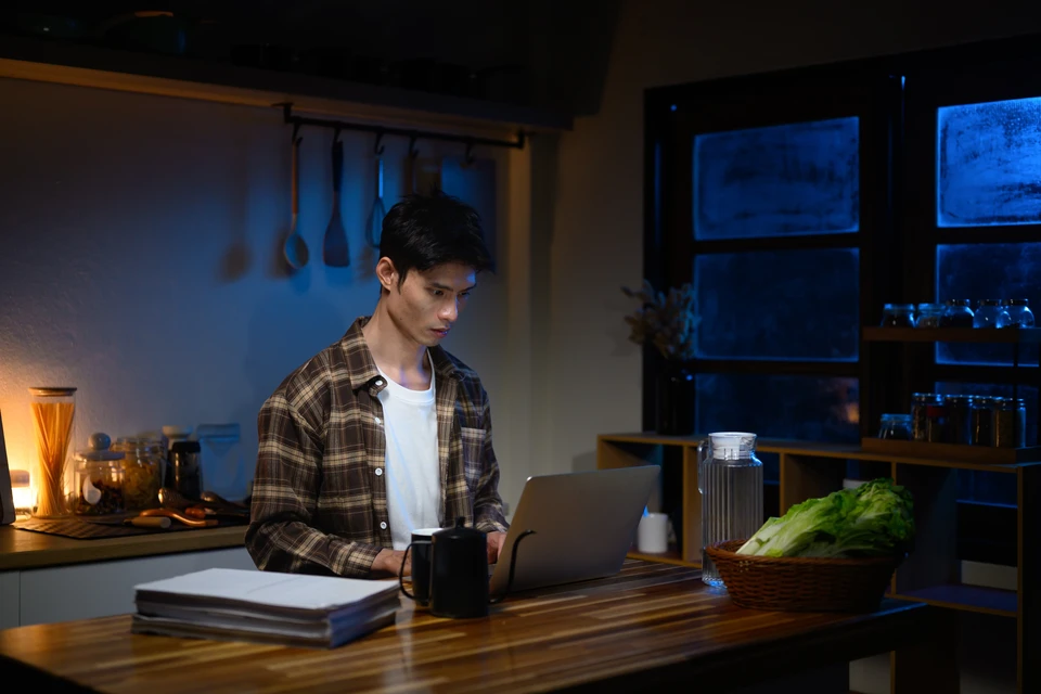 Mécanicien automobile en combinaison bleue remplaçant une batterie de voiture dans un garage professionnel