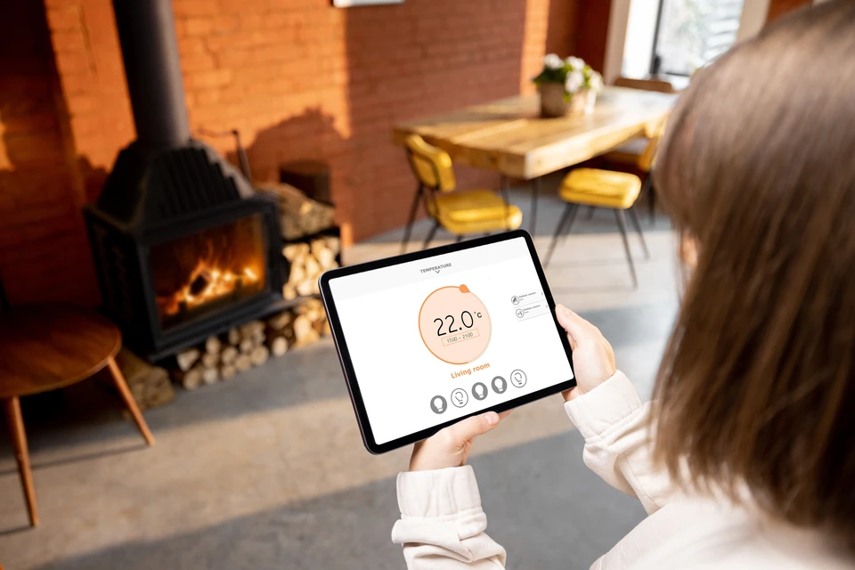 Travailleur masculin avec ordinateur tablette installant un système d'alarme dans la pièce
