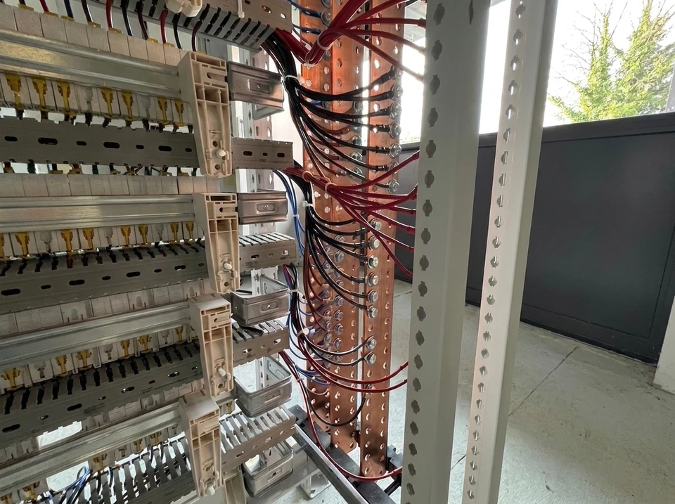 Jeune ingénieur travaillant sur des circuits électroniques dans un bureau moderne, manipulant des composants avec un fer à souder